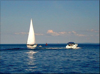 Sailboat and Powerboat passing at the harbor's mouth
